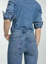 Jeans estilo flare tiro alto, color azul, con diseño crop, trabillas, cinco bolsillos y cierre de cremallera y botón.