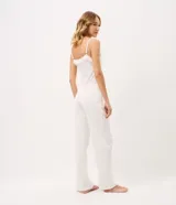 Pijama largo de dos piezas color blanco, compuesto por una musculosa con escote en V, tirantes finos regulables, detalles de encaje y botones frontales, y un pantalón largo con cintura elástica y cordón ajustable.