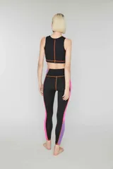 Crop top deportivo verde oliva sin mangas de lycra con banda lateral color block en amarillo y rosa y pespuntes overlock en contraste. Estampado de logotipo en la parte delantera.