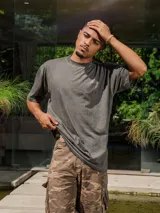 Remera de jersey color gris oscuro con efecto lavado, corte holgado y cuello redondo. Presenta un pequeño logo estampado en el pecho y un estampado grande en la espalda.