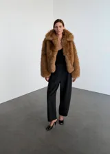 Pantalón de tiro alto con diseño tipo balloon, confeccionado en tejido mezcla de lana, con cierre lateral y forro interior.