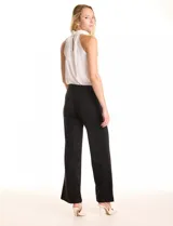 Pantalón wide leg negro de cintura alta con pretina prolongada que cierra con hebilla metálica en el lateral. Presenta una costura vertical frontal y pinzas de entalle en la parte posterior.