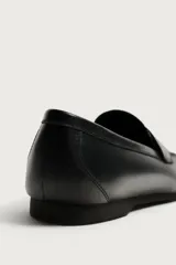 Mocasín de vestir negro de piel, con detalle de antifaz en el empeine, horma redonda y suela de goma Vibram. Colección especial Aaron Levine x Zara.