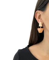 Aros colgantes con forma geométrica, con pieza superior rectangular color crema y pieza inferior cuadrada color ámbar.