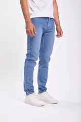 Pantalon jean de corte slim en color azul medio, con diseño clásico de cinco bolsillos y cierre frontal con botón y cremallera.