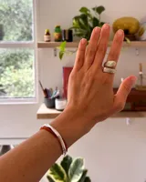 Anillo de diseño abierto con textura escamada que simula la piel de una serpiente, elaborado artesanalmente en metales nobles.