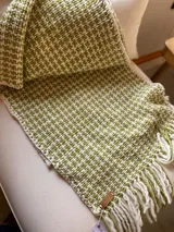 Caminero, manta o pie de cama tejido artesanalmente en lana teñida naturalmente, color verde y blanco.