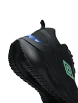 Championes deportivos Umbro modelo Fly, color negro con detalles en azul y verde neón en el logo lateral y la parte trasera. Presentan una suela robusta y diseño ergonómico.