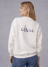 Buzo de cuello redondo color crudo, con calce relajado y estampa frontal artística en tonos oscuros que incluye la palabra 'Cruda'.