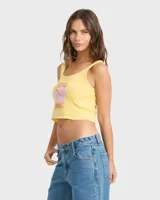 Top musculosa Billabong de corte crop en color amarillo, con diseño estampado frontal de flor tropical y texto en tonos rosados y naranjas.
