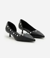 Zapato estilo kitten heel de cuero sintético negro, con punta fina y aplicación de pequeñas tachas metálicas a lo largo del borde superior.