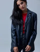 Blazer negro de eco cuero marca Baccini, con cuello con solapa, abertura central con botones y bolsillos delanteros.
