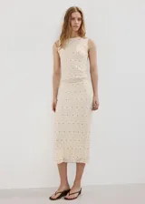 Top sin mangas de tejido texturizado con efecto arrugado y diseño entallado, de cuello redondo y color beige con pequeños detalles brillantes.