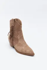 Bota texana de gamuza negra con caña baja, flecos laterales decorativos, costuras estilo western y taco bajo inclinado.