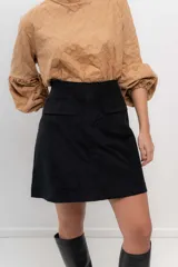 Minifalda negra de velvetine con spandex y bolsillos frontales.