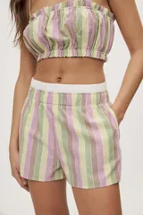 Short a rayas verticales en tonos verde, lila, amarillo y marrón, con tiro medio, cintura elástica en contraste y bolsillos laterales, de calce relajado.