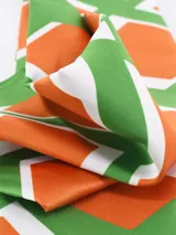 Pañuelo de seda o material similar, estampado con patrón de leopardo en tonos marrones y negros, con borde liso negro.