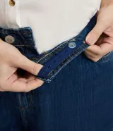 Pantalón de jean modelo wide leg, de tiro medio y corte amplio desde la cadera hasta el ruedo. Presenta cierre frontal con botón, bolsillos laterales y traseros, y trabillas en la cintura.