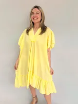 Vestido amarillo suelto con escote en V y mangas cortas con calados.