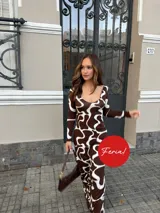 Vestido largo de manga larga con diseño estampado abstracto en tonos marrón y blanco, con escote redondo pronunciado.