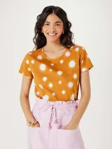 Remera color naranja con estampado de soles blancos y rosados.