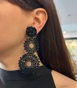 Aros colgantes con forma de círculos tramados con cristales color lila.