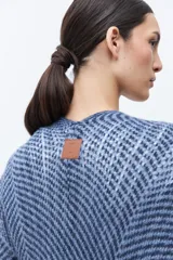 Ruana de punto color azul con estampado de espiga en dos tonos de azul, diseño holgado, con bolsillos y flecos en el borde inferior.