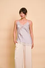 Musculosa celeste de satén con tirantes finos, escote en V y detalles de encaje transparente en diagonal y en el borde inferior asimétrico.