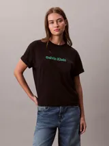 Remera Calvin Klein de manga corta y cuello redondo, color negro, con logo de la marca bordado en 3D en tono verde en el pecho. Presenta un corte regular y mangas con vuelta.