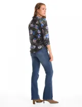 Camisa de gasa con estampado floral en tonos azules y rosados sobre fondo negro. Presenta cuello con solapa, escote en V, cierre frontal con botones y mangas tres cuartos con puños abotonados.