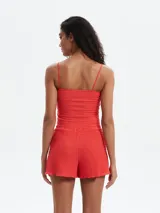Shorts de mujer color rojo, con textura fruncida o smock en toda la prenda y borde inferior ondulado.