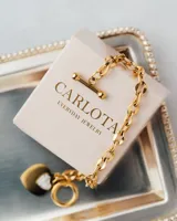 Pulsera dorada de eslabones gruesos con cierre tipo barra T y dije de corazón con incrustaciones brillantes.