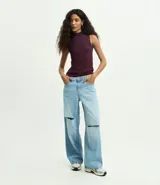 Musculosa básica de cuello alto, sin mangas, confeccionada en una mezcla de algodón, modal y elastano. Presenta un diseño ajustado y minimalista, ideal para uso diario.