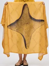 Pareo largo de viscosa en color verde menta, con diseño estampado que presenta gráficos abstractos y una figura central destacada en negro. Es una prenda liviana y fresca, ideal para usar sobre el traje de baño o como falda envolvente.