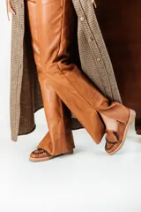 Mocasines de cuero marrón con diseño artesanal, detalle de costuras trenzadas en contraste en la parte frontal y suela baja con taco cómodo.