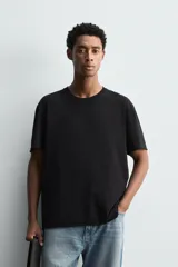Camiseta de corte relajado confeccionada en algodón ligero, con cuello redondo y mangas cortas con bordes de acabado irregular.