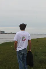 Remera de algodón con efecto acid wash en color azul, corte recto, mangas cortas y estampa en la espalda con diseño pixelado de cerezas y el texto "Cherry Season".