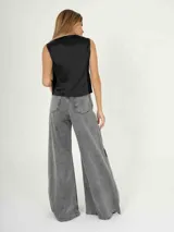 Chaleco negro de terciopelo con botones al frente y corte a la cintura.