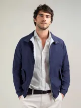 Campera Harrington color beige, con cuello alto abotonado, cierre frontal completo y bolsillos laterales con solapa y botones a presión. Puños y cintura elastizados de rib.