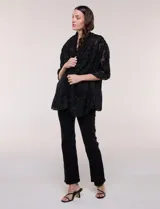 Pashmina rectangular negra con textura, bordados florales en relieve de efecto deshilachado y ligera transparencia.