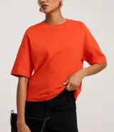 Blusa basica oversize de algodon color marron, con cuello redondo y mangas cortas con sisas desplazadas.
