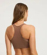 Soutien femenino color marrón, confeccionado en poliamida texturizada, con diseño de espalda nadador y sin copa. Presenta un elástico en la base con el logo de la marca.