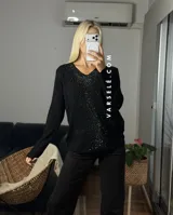 Sweater de punto color bordó con escote en V y detalle de strass aplicado en la parte frontal. Presenta mangas largas y corte holgado.