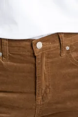 Pantalón de pana color marrón, de corte wide leg y tiro medio, con ruedo deshilachado.