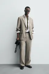 Pantalón de corte straight relaxed fit confeccionado en tejido de lino con efecto lavado. Presenta cierre frontal con cremallera y botón, bolsillos laterales y bolsillos traseros de vivo.
