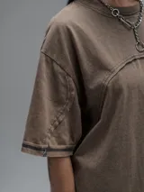 Remera de manga corta con diseño oversize, confeccionada en algodón con proceso batik artesanal en tono óxido. Presenta recortes superpuestos en el frente y costuras expuestas en mangas y cuerpo.