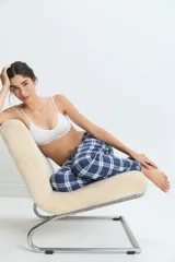 Pantalon de pijama con estampado de cuadros en tonos azul, blanco y rojo, con cintura elástica y corte holgado.