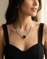 Collar tipo gargantilla de acero con cadena de eslabones planos y dije circular central con piedra ónix negra.