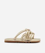 Sandalia plana dorada, estilo slide, con tiras anchas acolchadas y anudadas sobre el empeine. Posee una suela con relieve y plataforma baja.