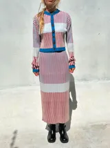 Falda midi de punto acanalado con diseño multicolor de rayas verticales en tonos rosado, rojo, celeste y blanco, con pretina elástica de tiro alto y corte tipo lápiz.